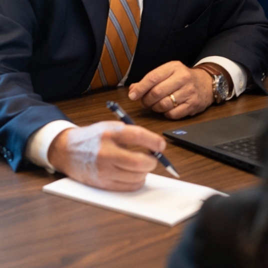 Hombre de negocios tomando notas durante una reunión.