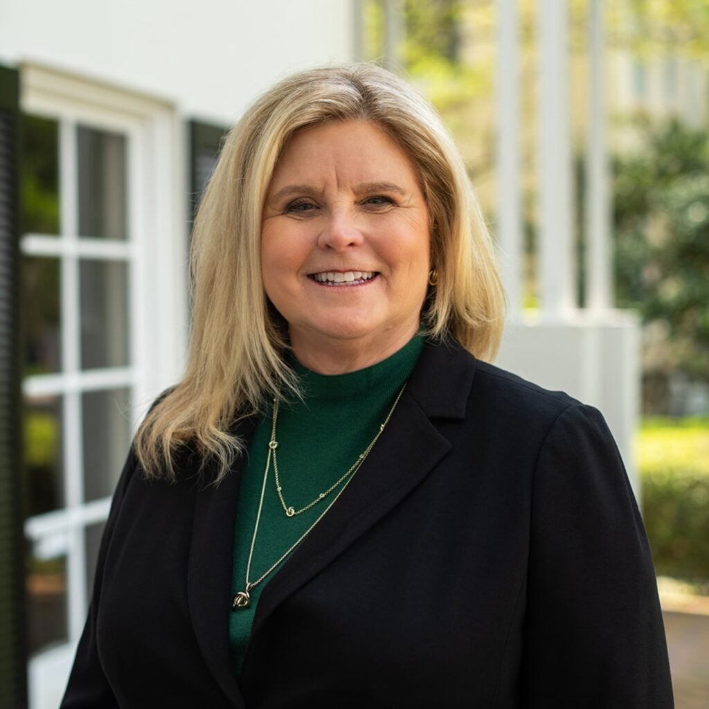 Smiling woman in black blazer outdoors