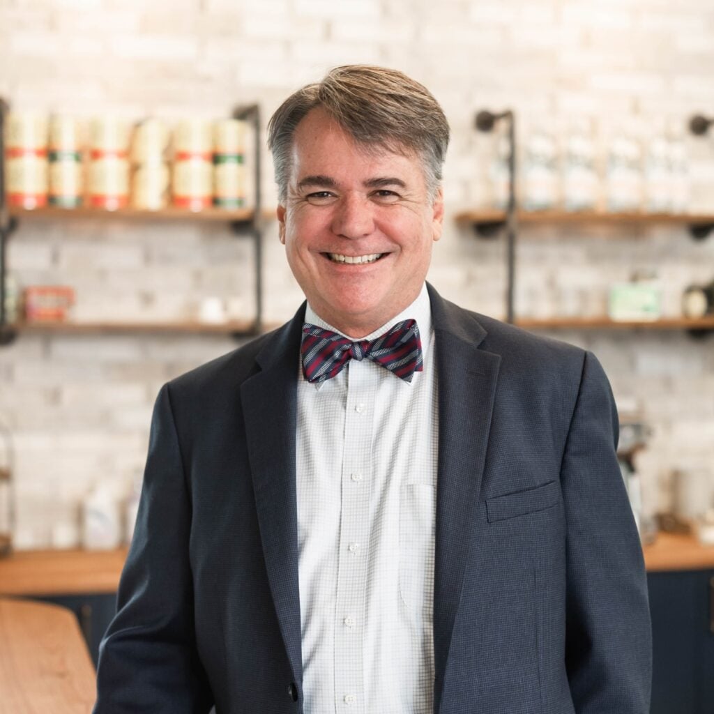 Smiling man in suit with bow tie in office