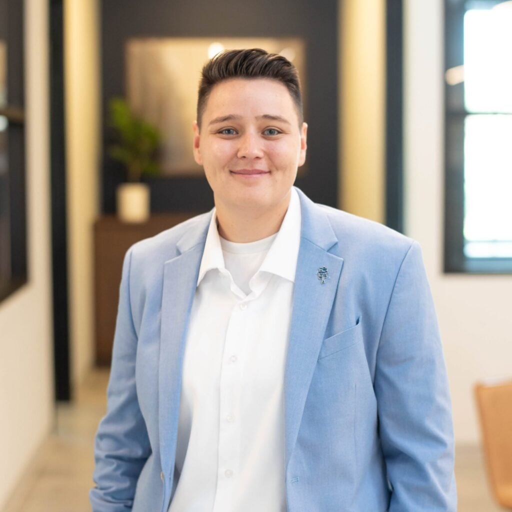 Person in blue blazer smiling indoors