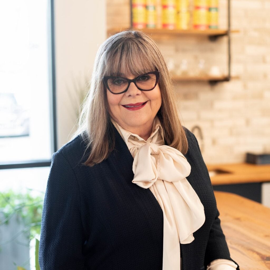 Smiling person wearing glasses and business attire