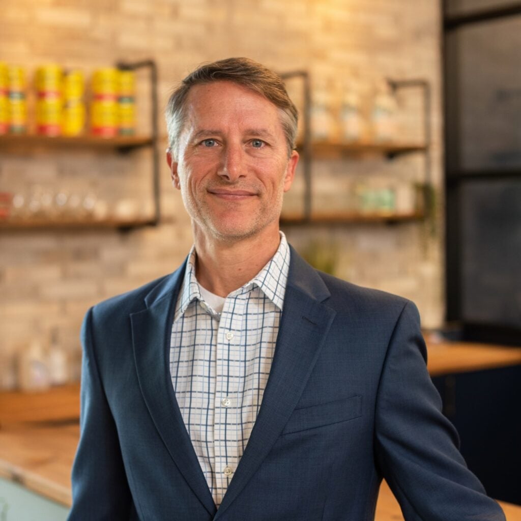 Smiling man in suit in modern office setting.