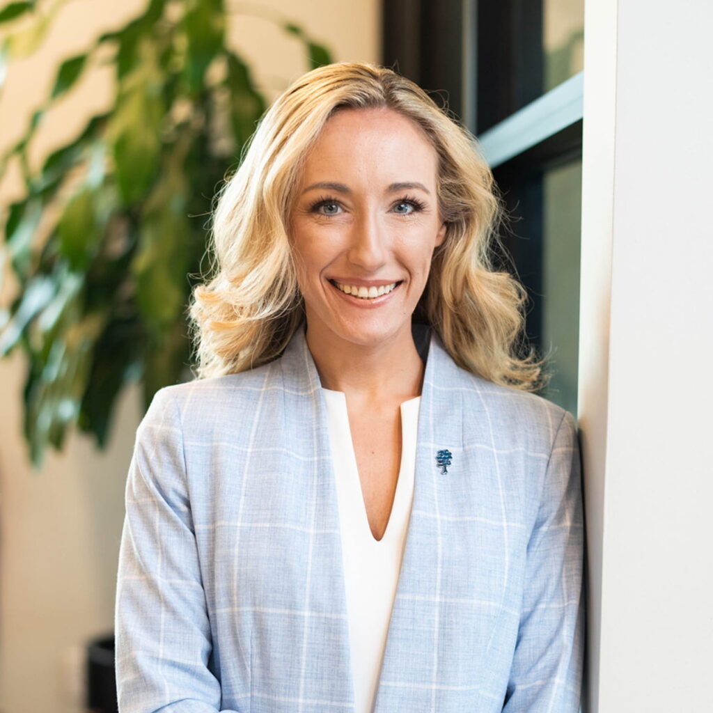 Smiling blonde businesswoman in light blue plaid blazer
