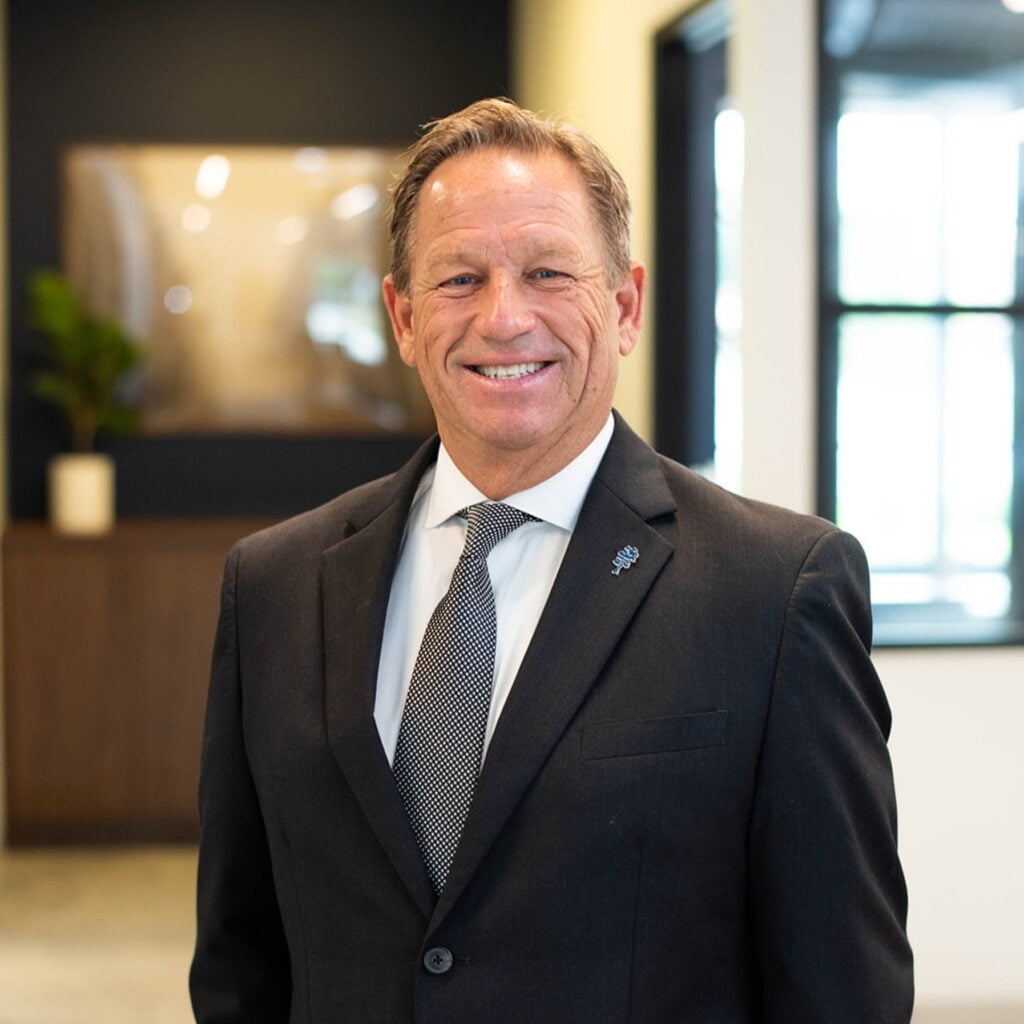 Smiling businessman in suit standing in a modern office