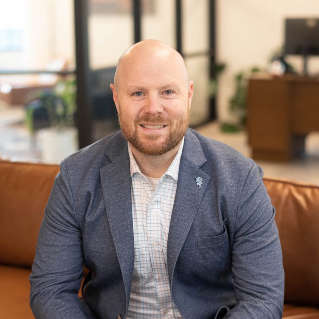 Smiling man in business attire sitting indoors
