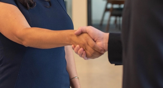 Primer plano de dos personas estrechándose la mano en interiores