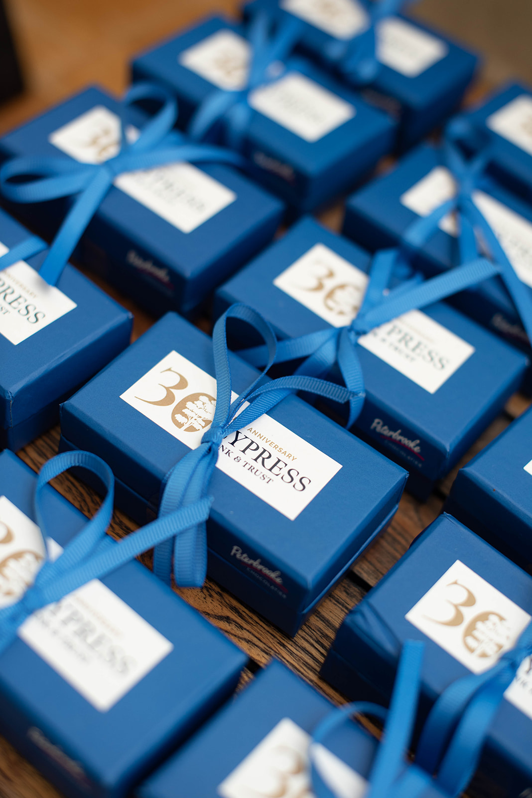 Cajas de regalo con lazo azul celebrando el aniversario de Cypress Bank & Trust