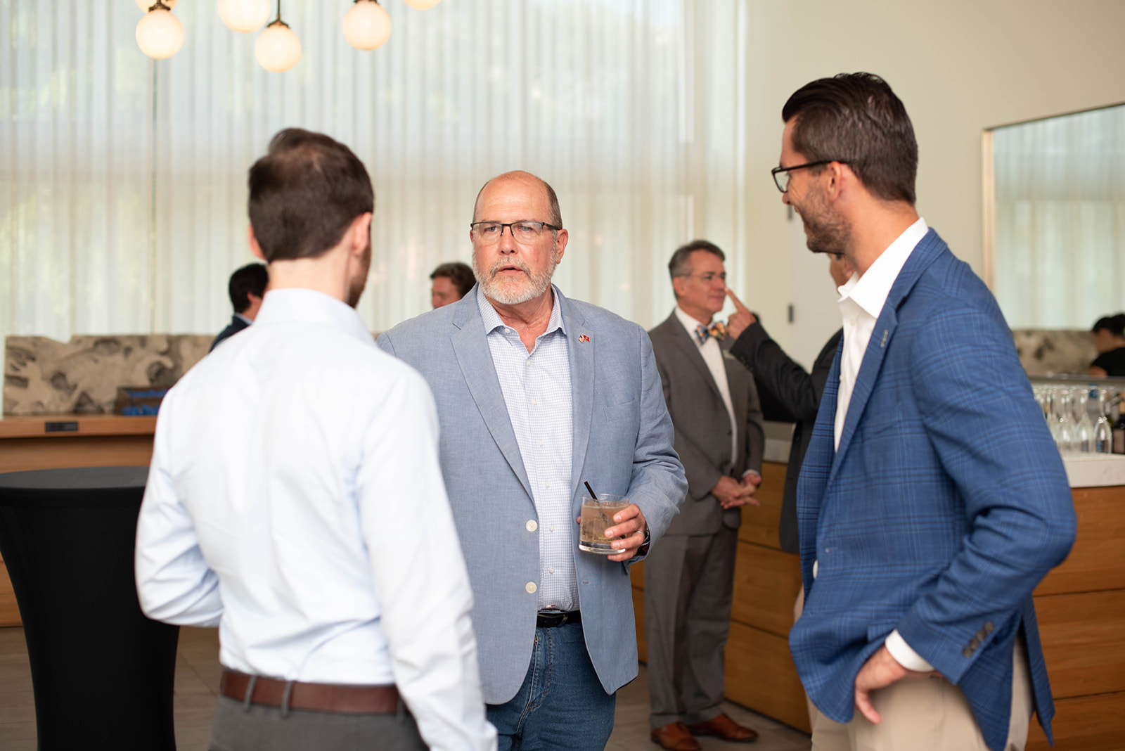 Los profesionales conversan en un evento de networking en interiores.