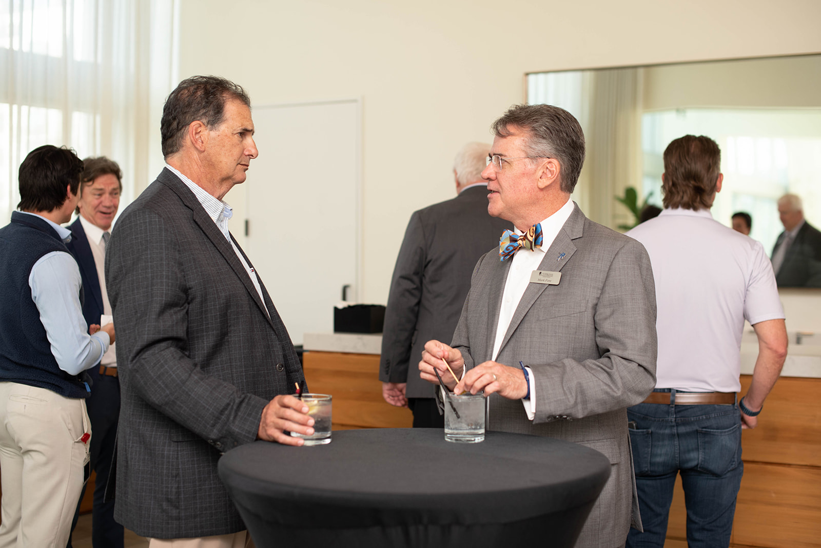 Dos hombres conversan en un evento de networking en interiores