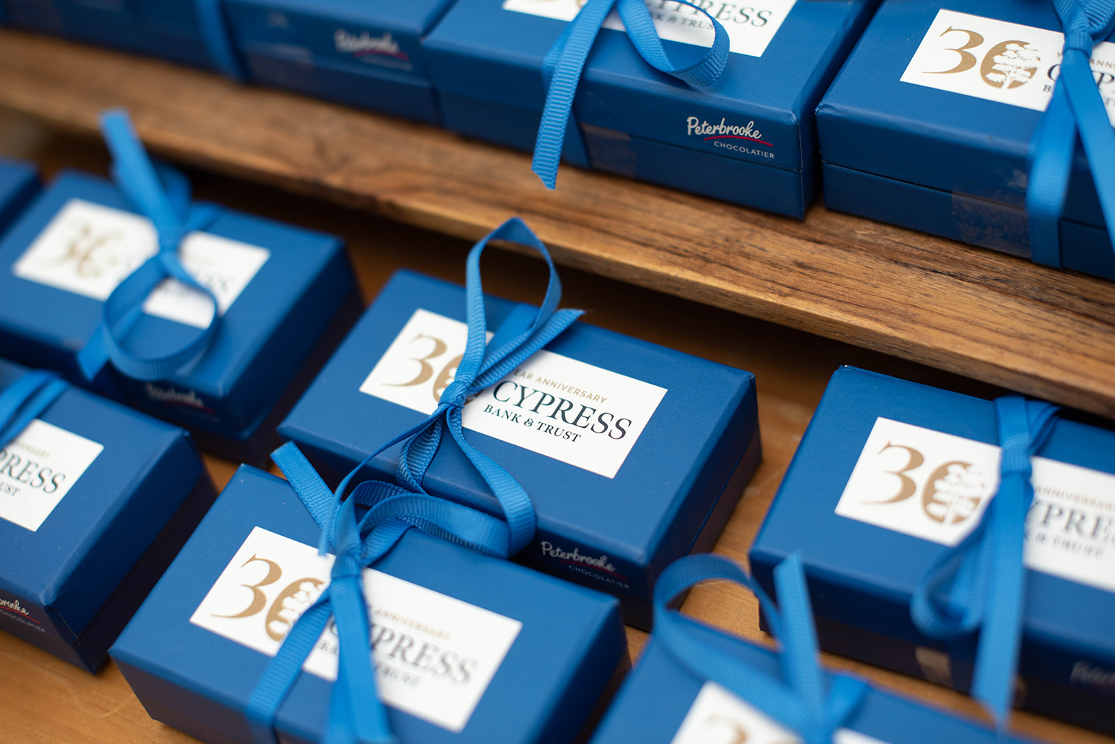 Cajas de chocolates con lazo azul en estantes de madera