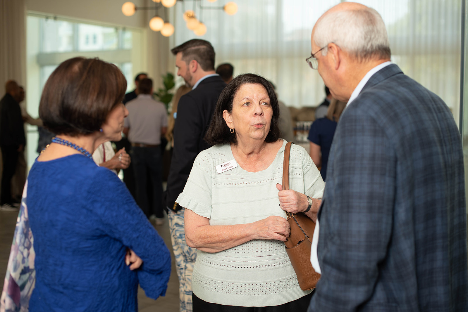 Los asistentes conversan en un brillante evento de networking en interiores.