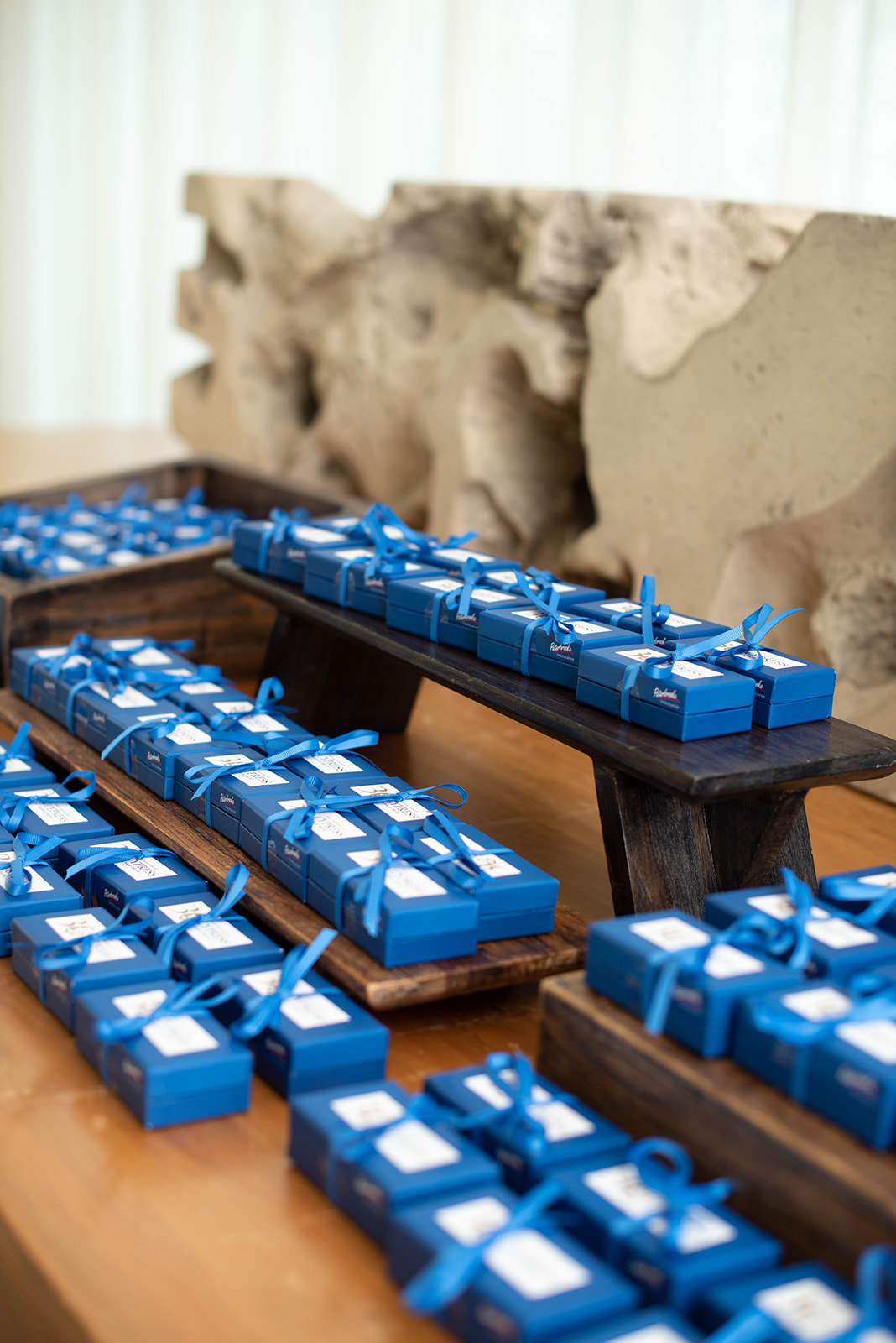 Cajas de regalo envueltas en cinta azul dispuestas en estantes de madera