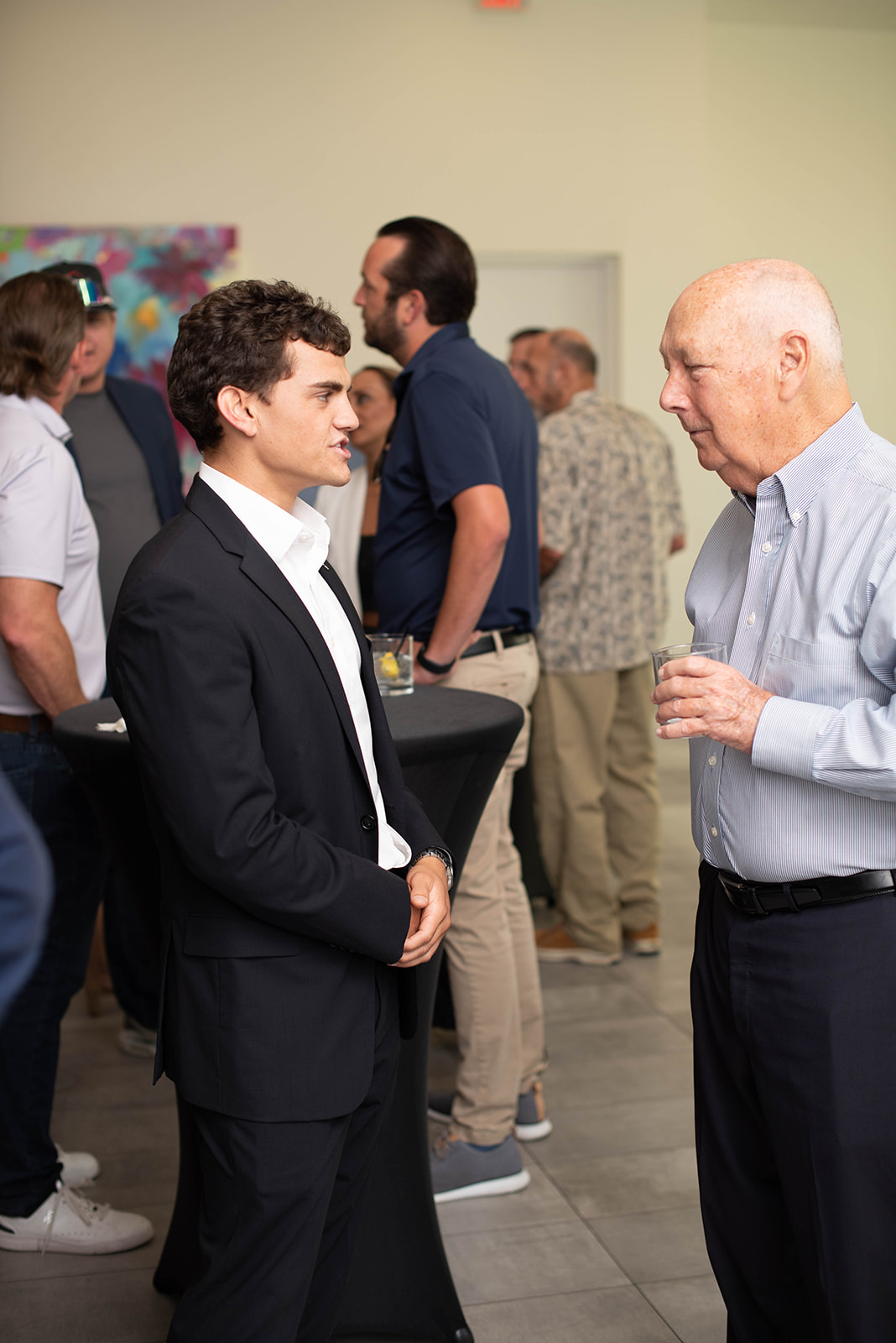 Dos hombres conversan en un evento de networking en interiores.