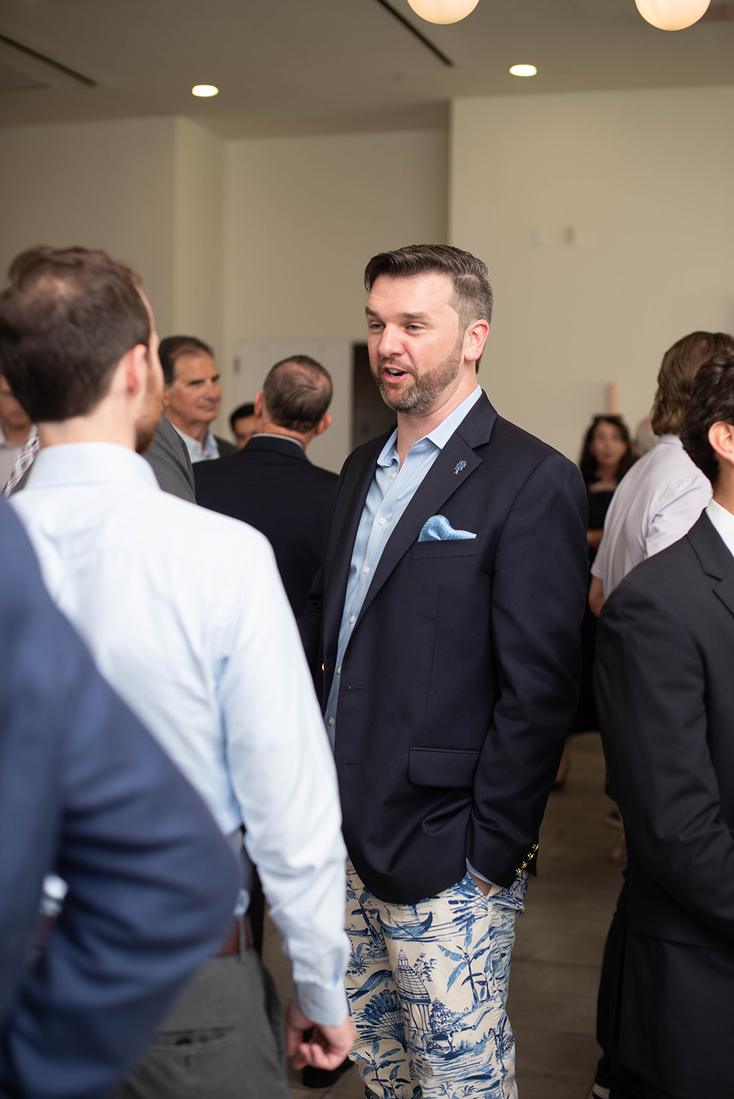 Hombre con blazer socializa en un evento de networking en interiores