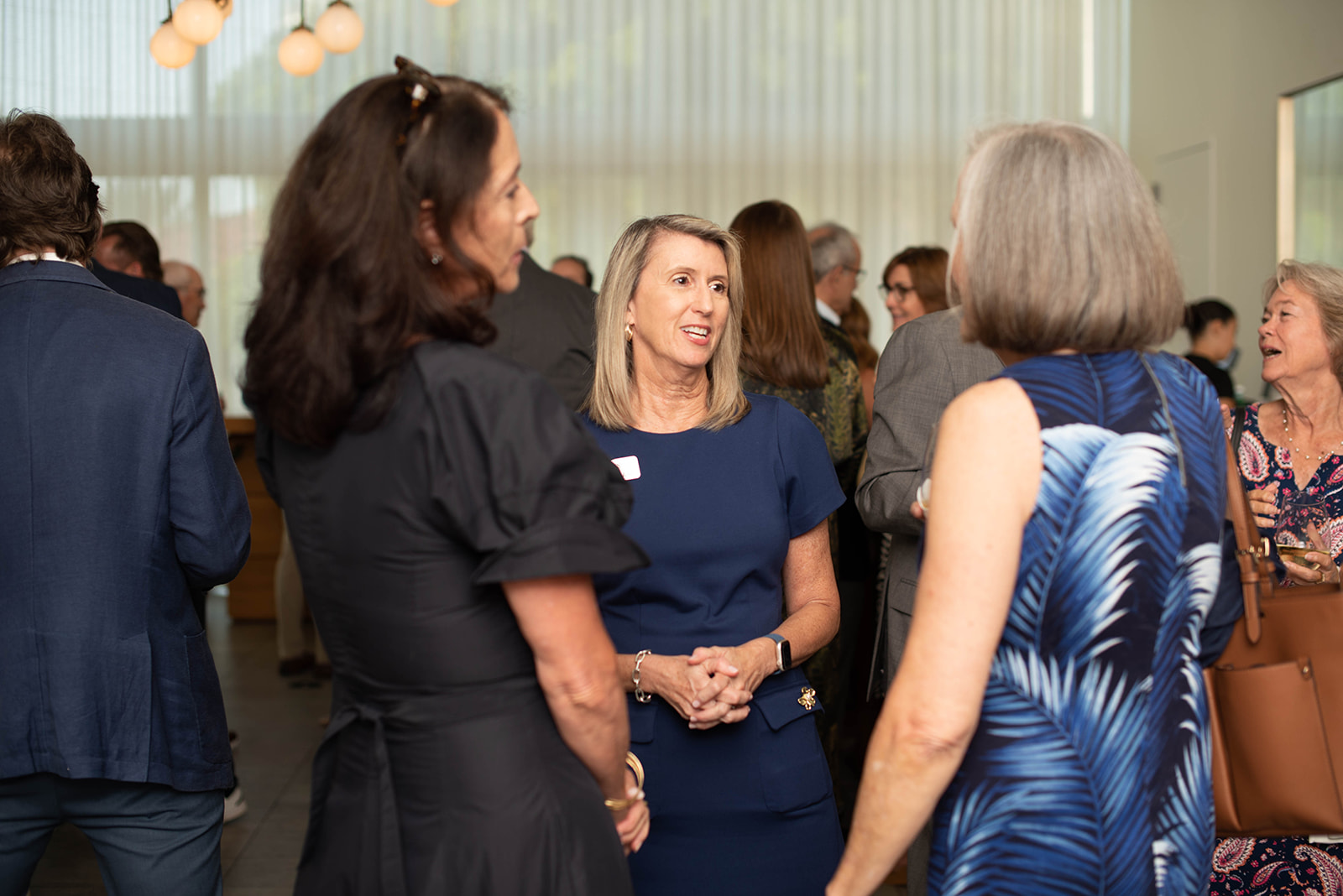 Los invitados conversan en un evento de networking en interiores.