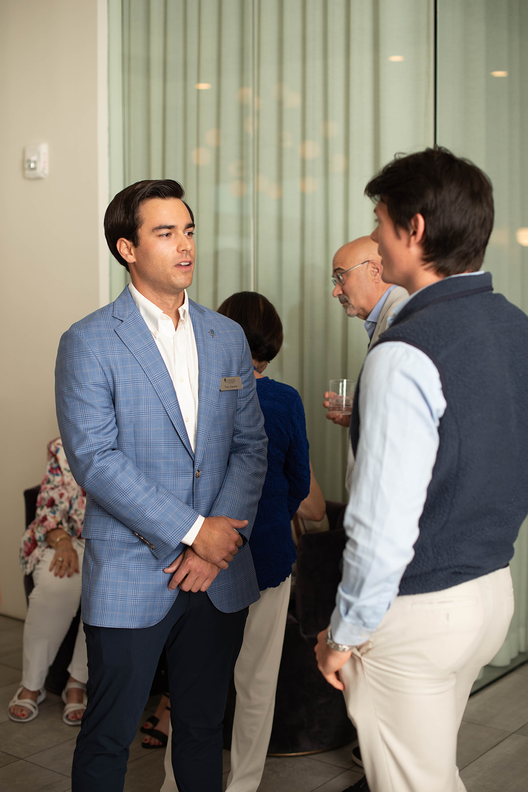 Dos hombres conversan en un evento de networking en interiores.