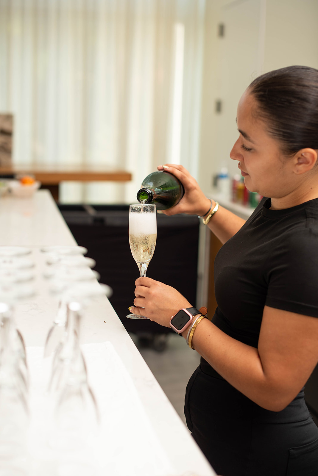 Mujer vierte vino espumoso en una copa de champagne