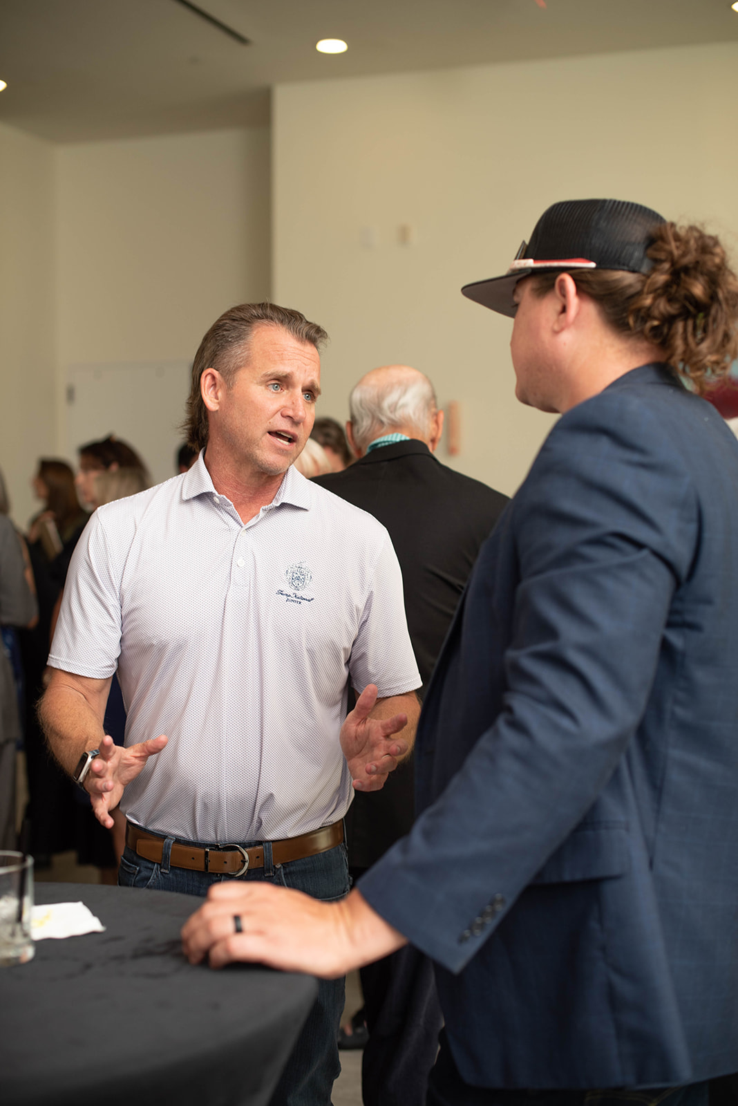 Dos hombres conversan en un evento de networking en interiores