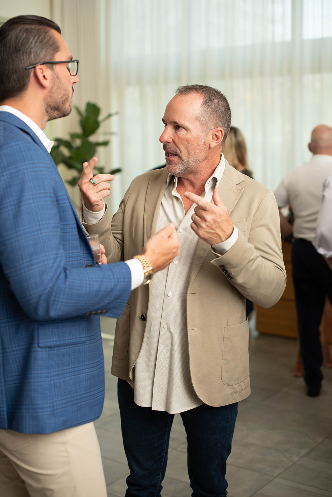Dos hombres conversan en un evento de networking en interiores.
