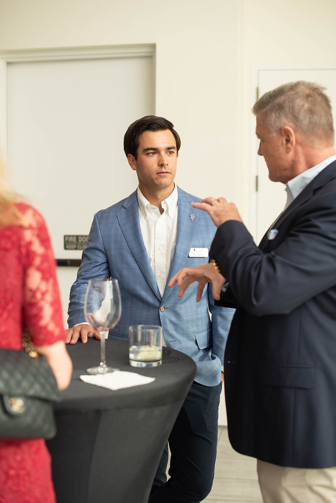 Profesionales conversan alrededor de una mesa de cóctel en un evento de networking