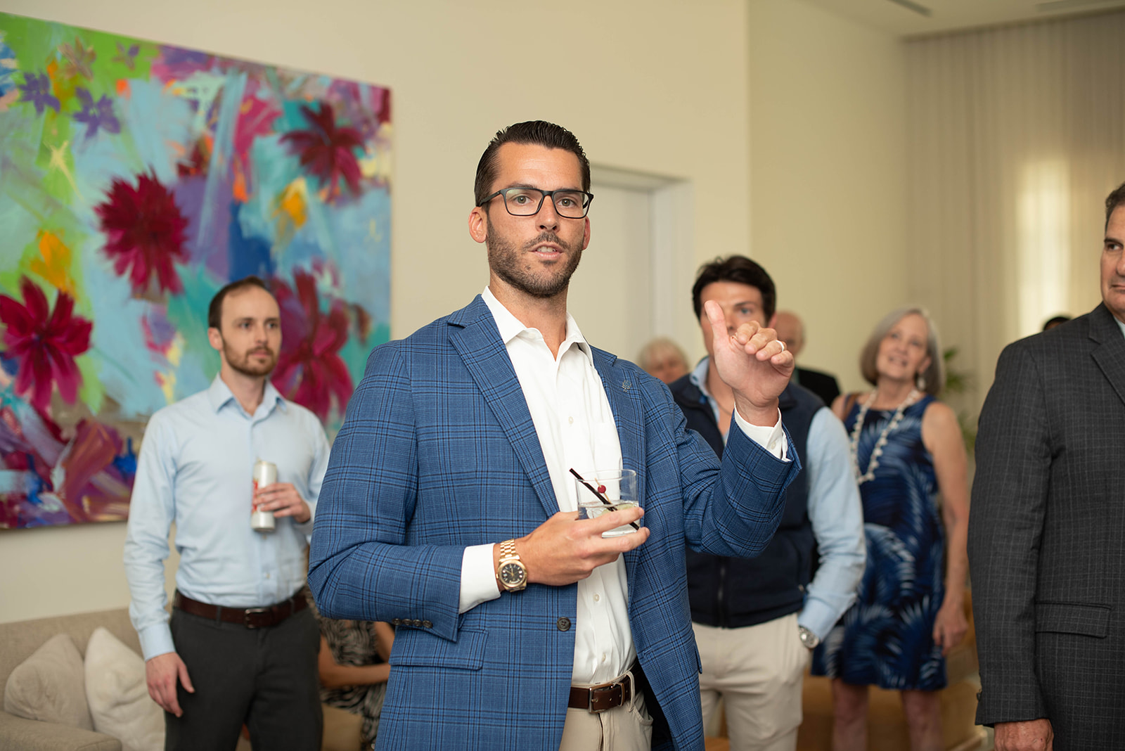 Hombre con blazer azul hablando en una reunión en interiores