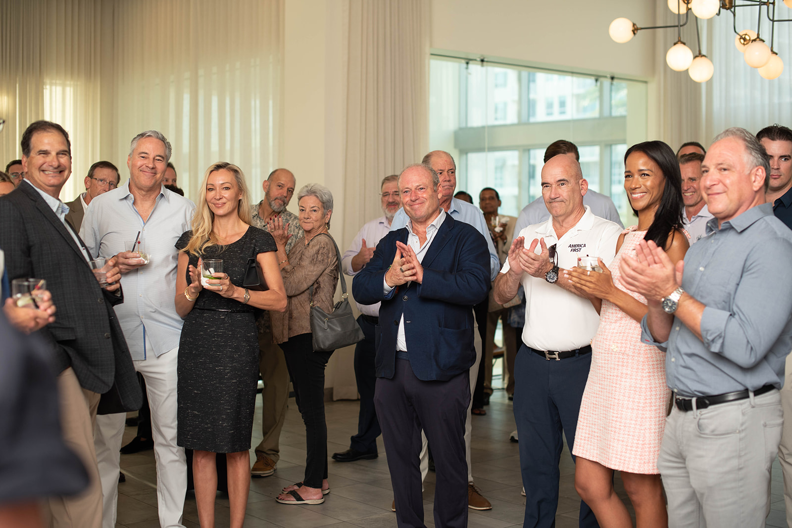 Los invitados aplauden en una elegante recepción en interiores.