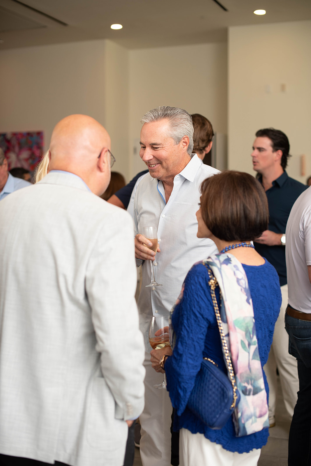 Los invitados socializan con vino en una recepción en interiores