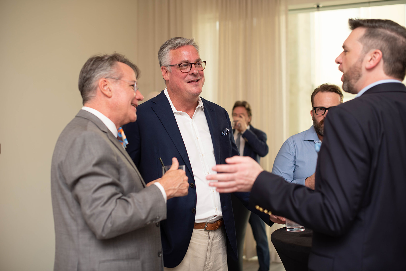 Hombres de negocios haciendo contactos y conversando en un evento social en interiores