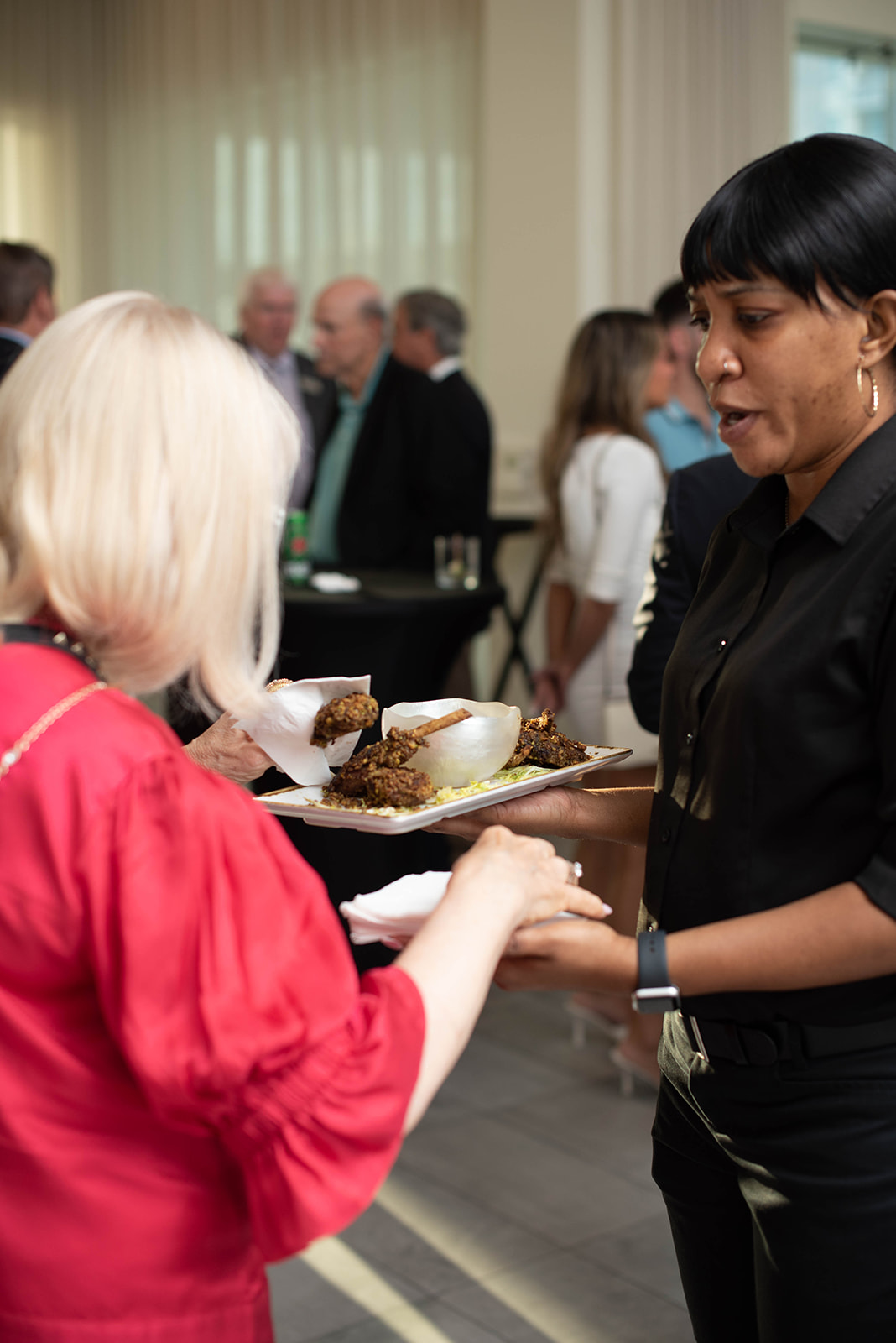 El servidor ofrece aperitivos a los invitados en la recepción interior.