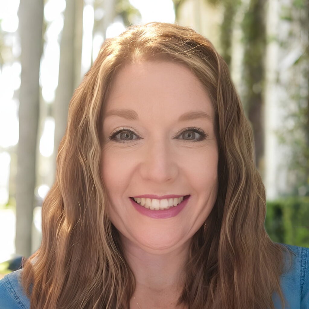 Smiling woman with long brown hair outdoors