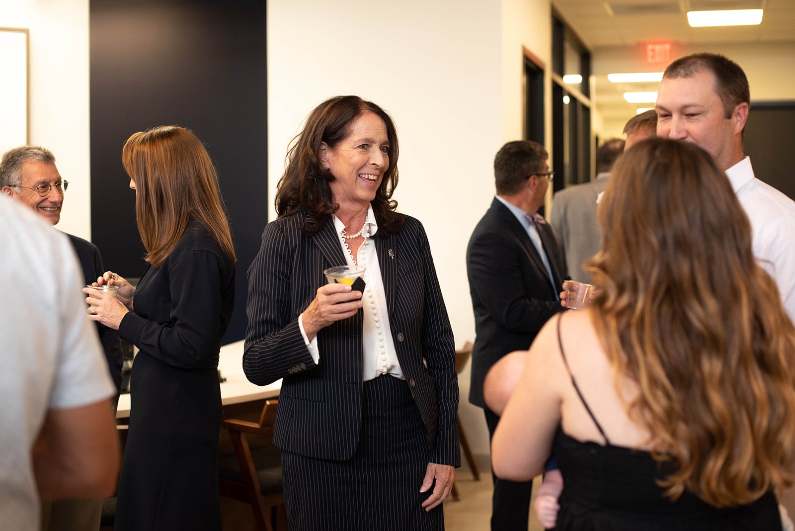 Los invitados socializan en una recepción empresarial en interiores