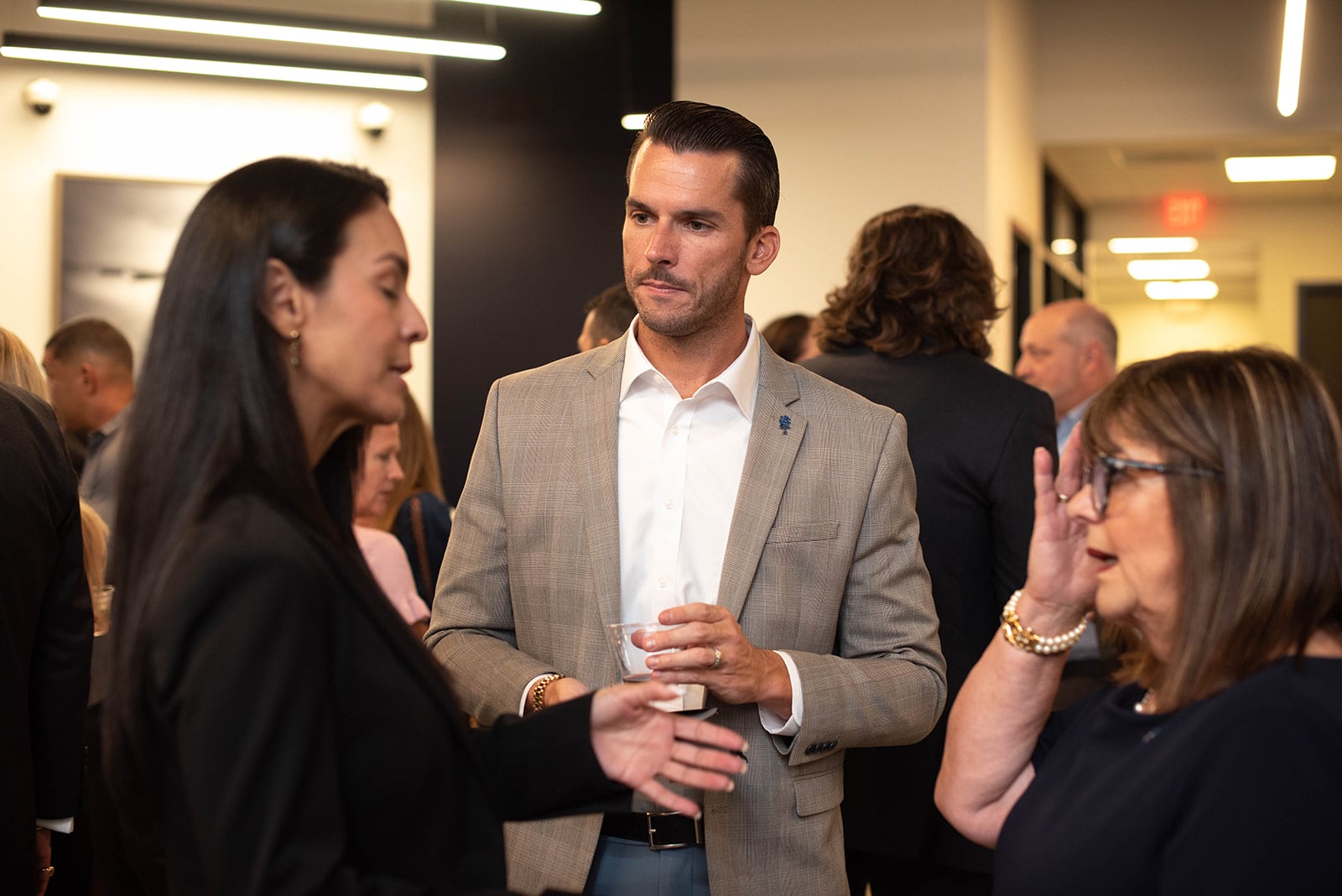 Los profesionales conversan en un concurrido evento de networking en interiores.