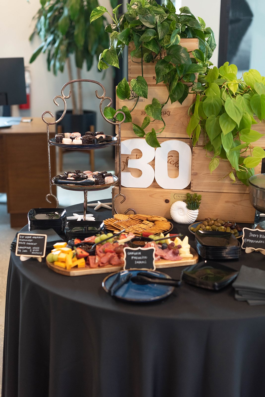 Elegante mesa de charcutería para el trigésimo cumpleaños con vegetación
