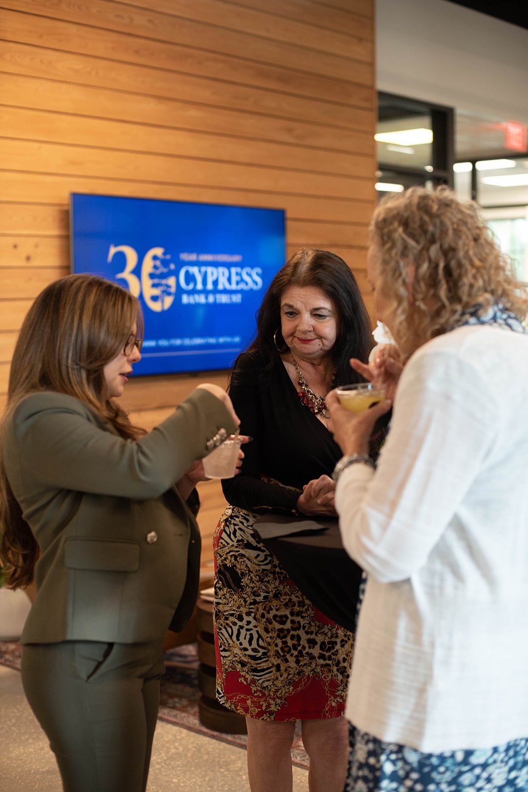Tres mujeres charlando en un evento del Banco Cypress