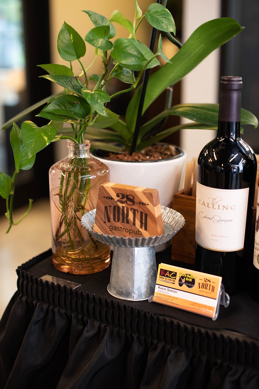 Botella de vino, plantas y mesa de exhibición del restaurante