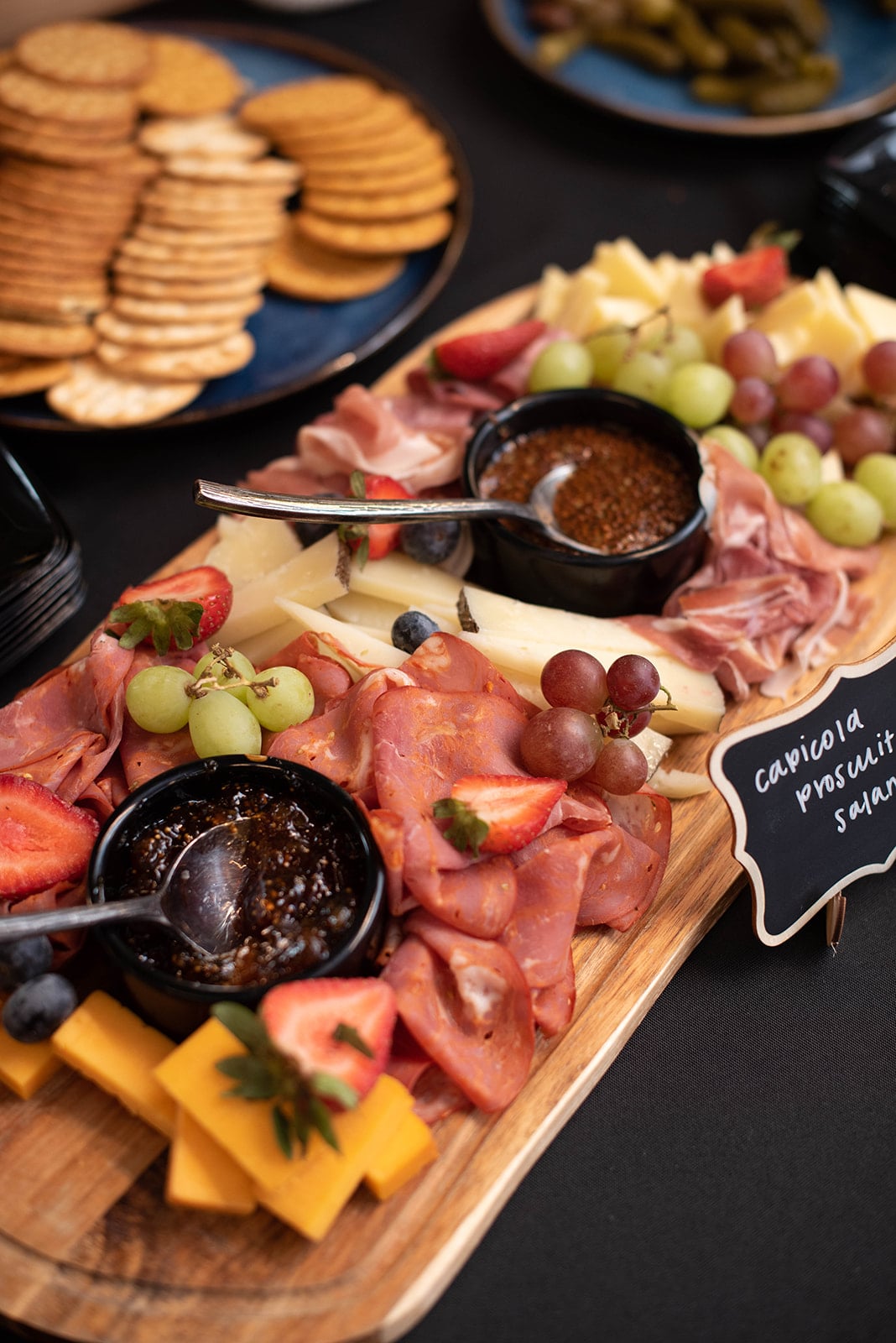 Tabla de embutidos con carnes, quesos, frutas, untables y galletas