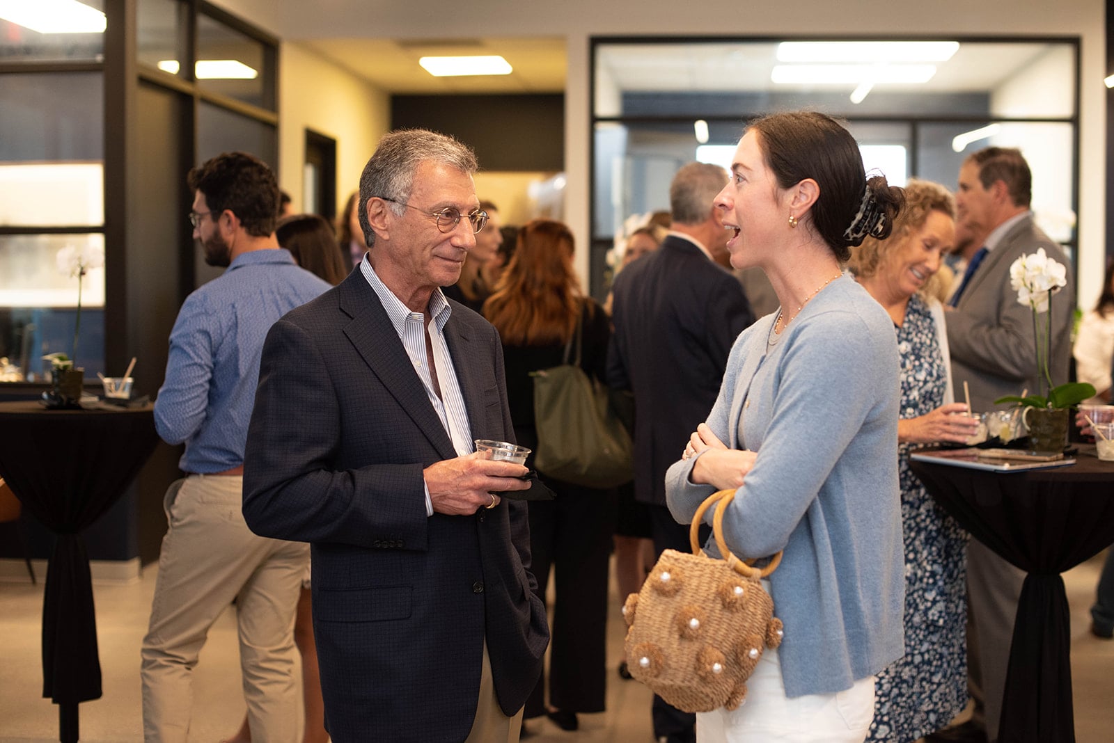 Los invitados conversan en una recepción de networking en interiores.