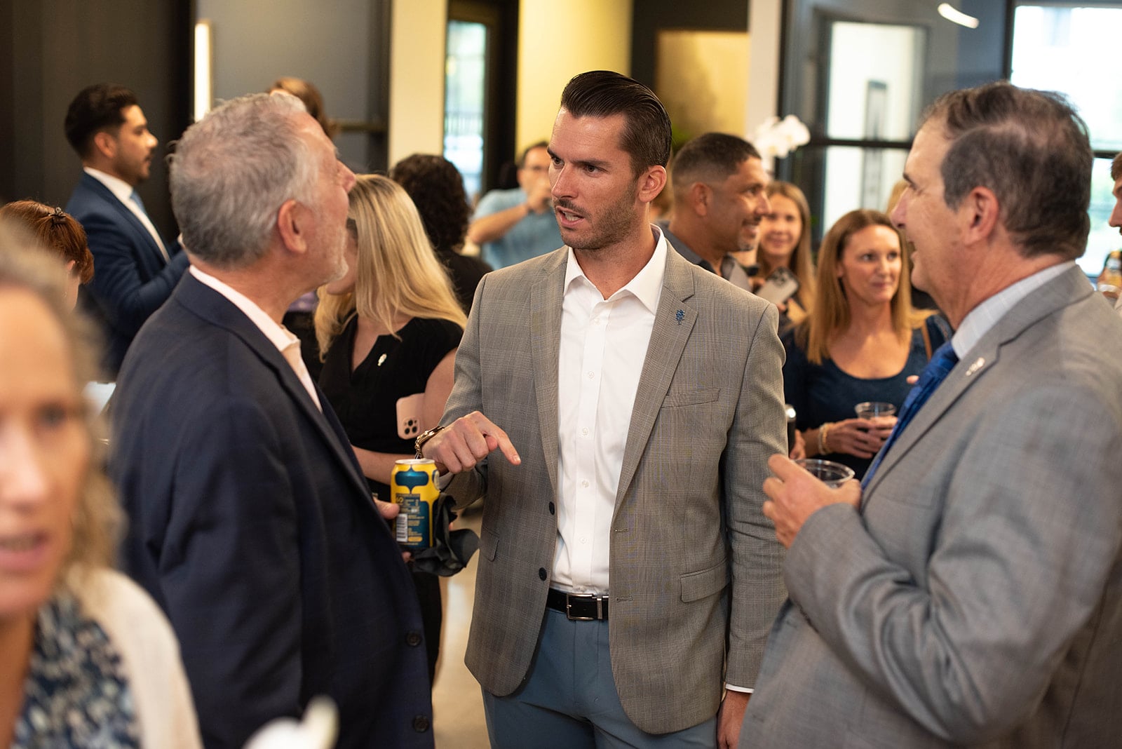 Los profesionales conversan en un concurrido evento de networking en interiores.