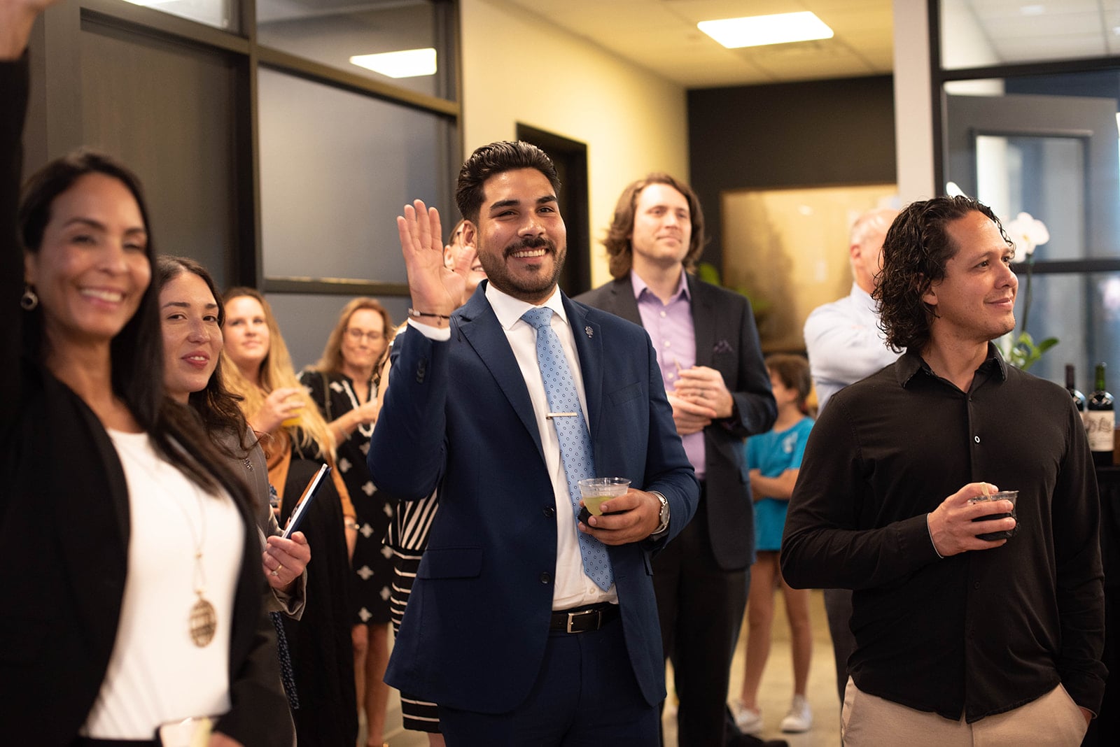 Hombre sonriendo con traje saludando en una reunión de oficina