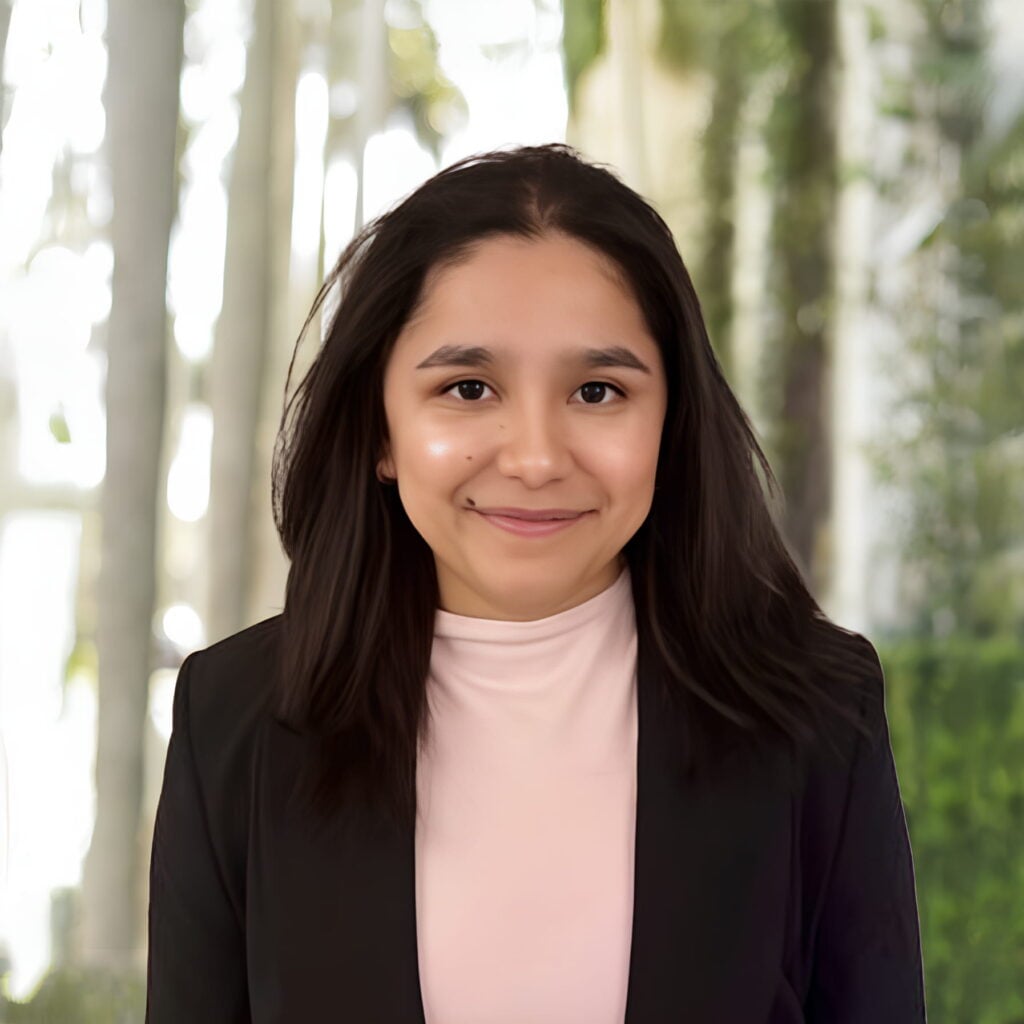 Smiling woman in black blazer and pink top